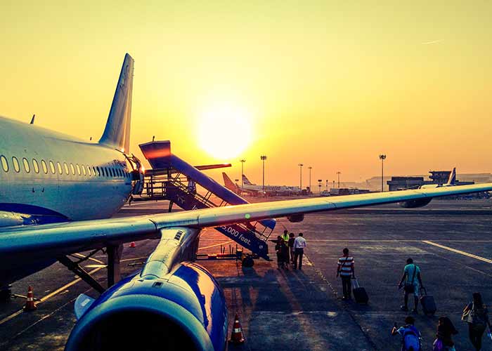 travelers boarding an aircraft at dusk